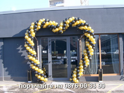 Арка във формата на сърце с бели и златни балони.